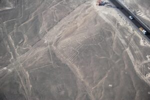 Drone shot of iconic Nazca Lines geoglyphs in Peru's desert landscape.